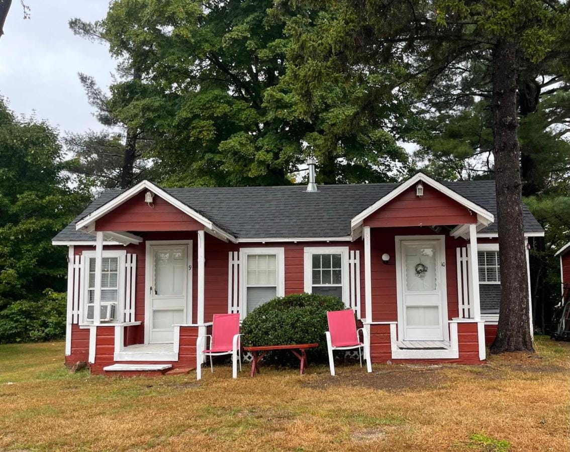 Two of the red cabins side by side, each with its own covered porch